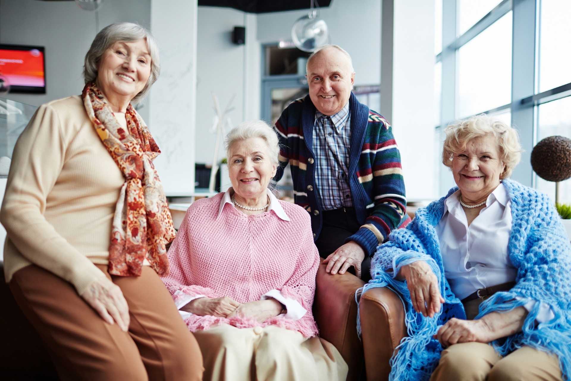group-of-happy-seniors-in-a-bright-room A group of happy seniors posing together and smiling.